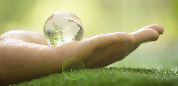 Extended hand with crystal world ball. Manfisa with environmental conservation